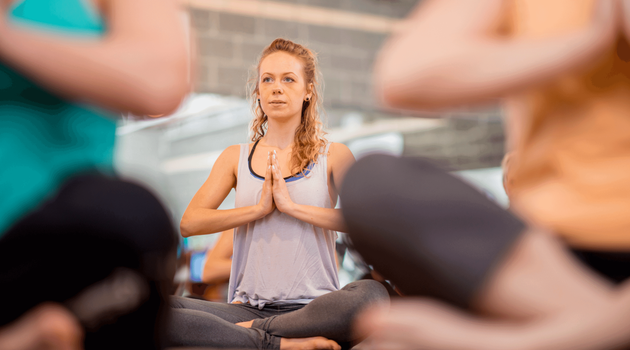 Woman sitting in a yoga pose with hands together - the link between diastasis recti and breathing