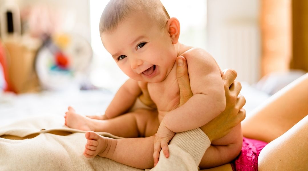 lauginh baby sitting on mother's tummy - storp calling it mommy tummy